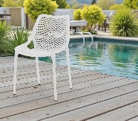 Chaise blanche sur terrasse au bord de la piscine, ambiance détente et soleil, parfait pour un week-end d'été en extérieur.
