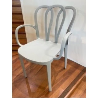 Chaise moderne en blanc avec accoudoirs et dossier artistique, idéale pour une salle à manger ou un espace de détente. Parfaite pour une décoration intérieure élégante et contemporaine.