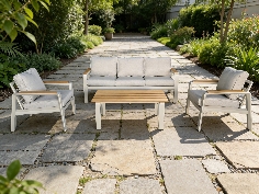 Mobilier de jardin relaxant avec fauteuils et table en pierre, idéal pour profiter d’un samedi ou dimanche en plein air dans un espace vert élégant.