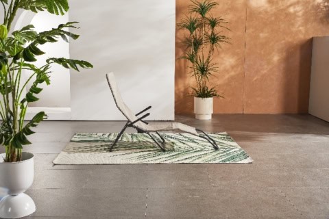 Sillonnez un espace intérieur moderne avec un fauteuil relax en extérieur, éléments de décoration verdoyants, parfaits pour un week-end reposant.