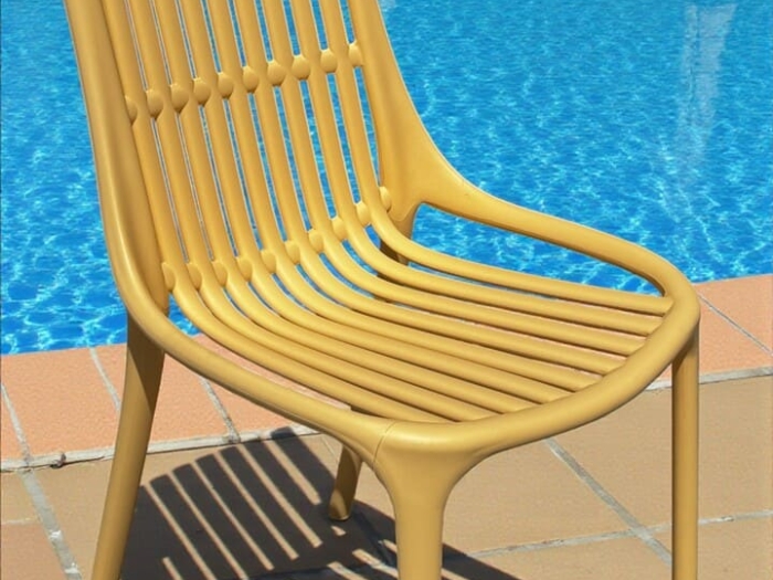 Chaise de jardin jaune en plastique avec lattes en extérieur, idéale pour aménager un espace détente au bord de la piscine ou dans un jardin ensoleillé.