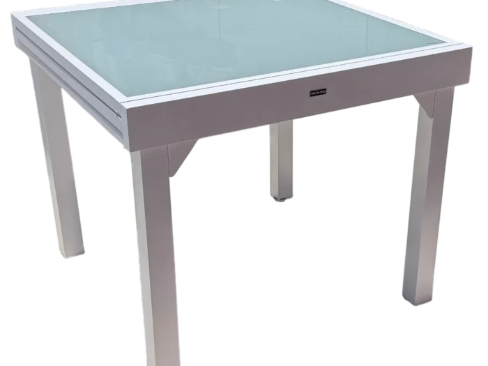 Table EOS extensible 90/180x90cm en aluminium blanc avec plateau en verre gris, idéale pour 8 personnes. Design moderne et pratique, parfaite pour les repas en famille ou entre amis.