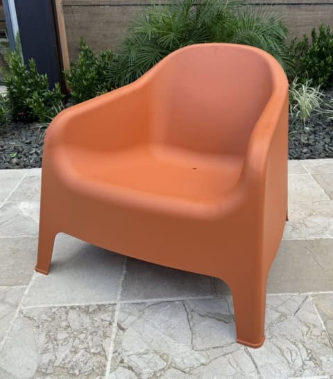 Assise en plastique orange pour extérieur ou intérieur.