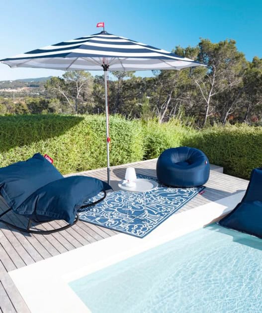 Pool lounge extérieur avec parasol et fauteuils confortables pour un week-end détente en Provence. Ambiance oxford blue, parfaite pour profiter du soleil et de la nature.